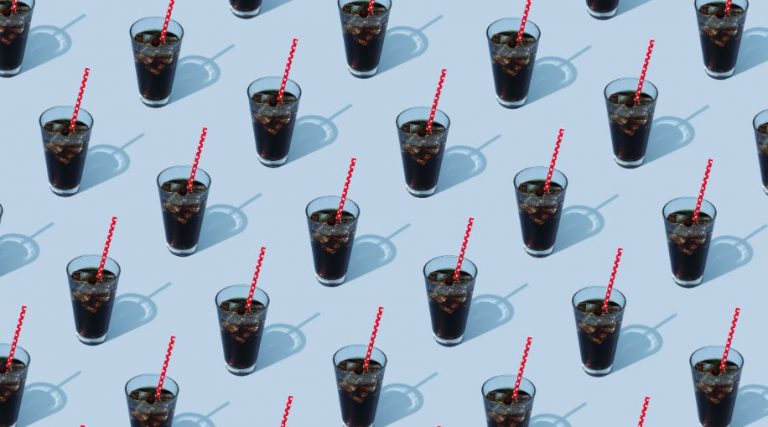A pattern of a repeated image of a glass of soda with a red straw on a blue background.